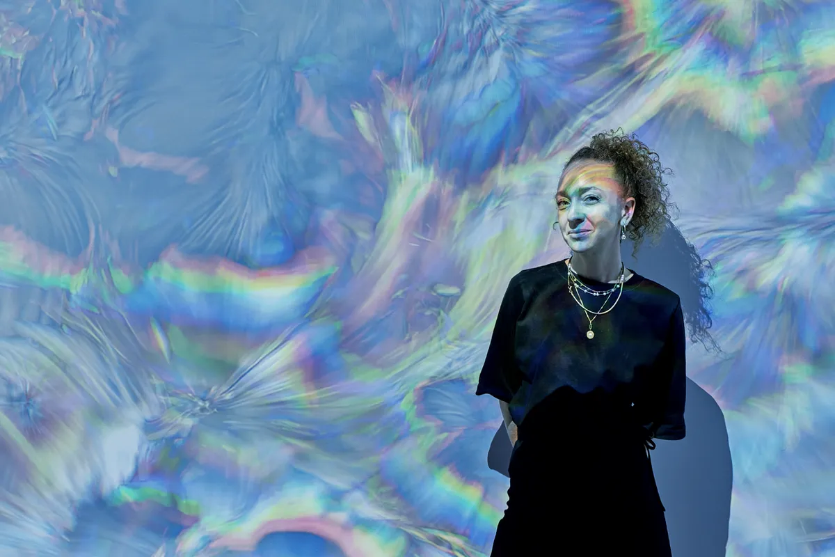 Kinda Studios, Emergence — a figure standing before the installation's projected light field