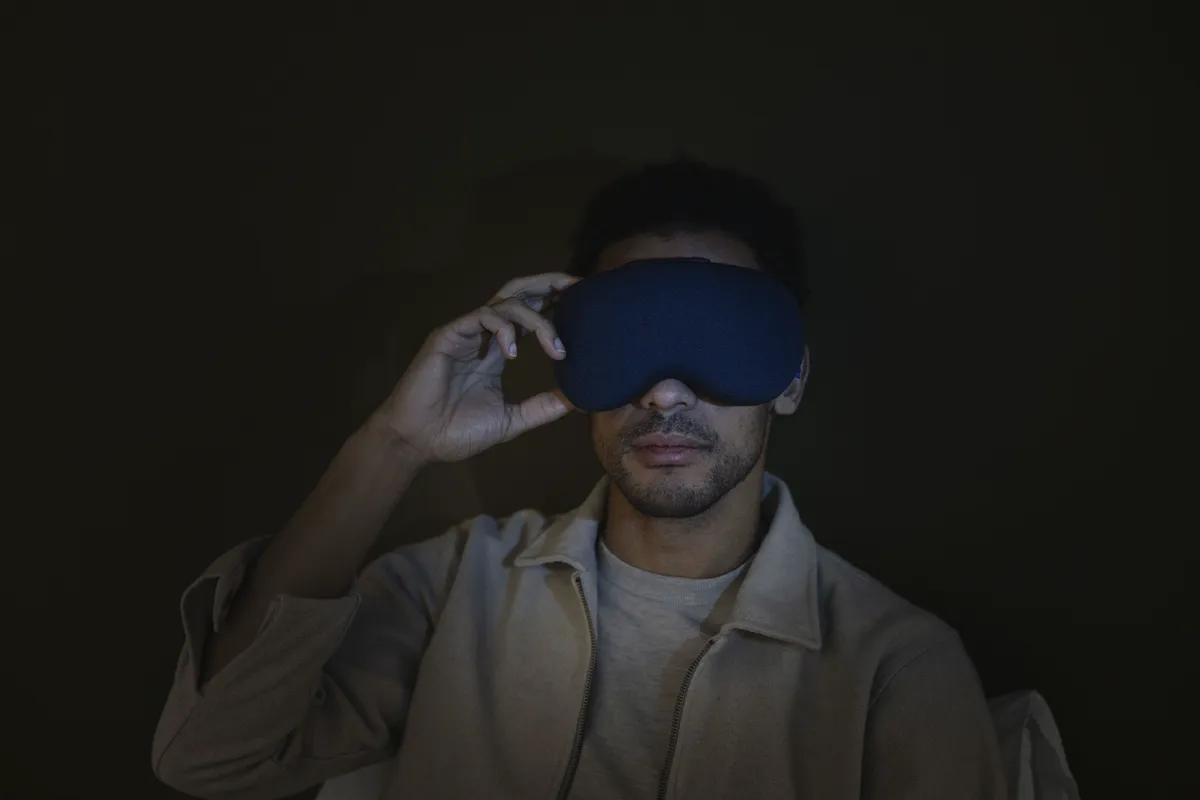 Lumenate, a guest wearing the Nova mask in a darkened room